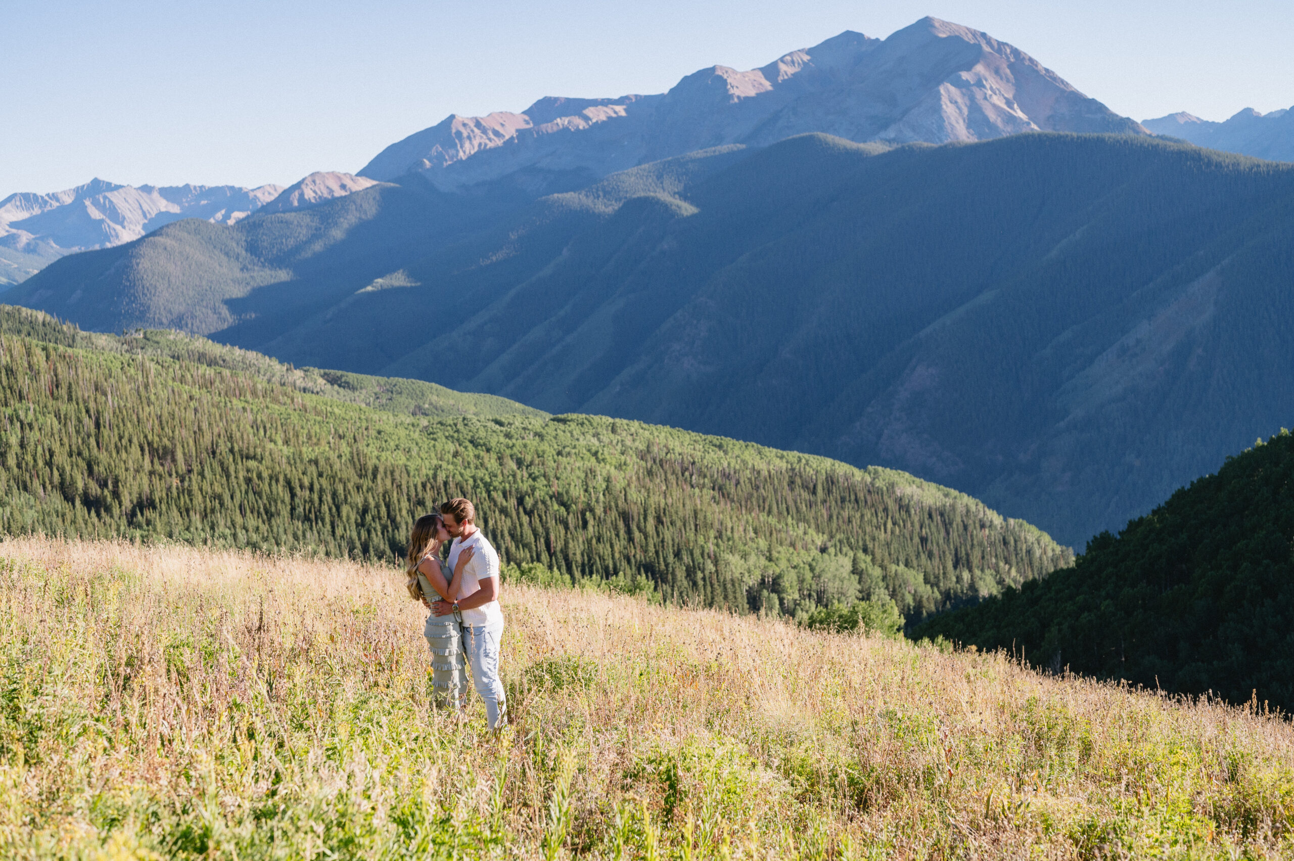 engagement photo of couple kissing in the fields of Aspen Mountain