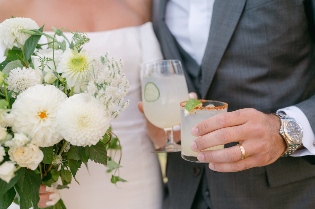 A bride and groom toast with margaritas on their wedding day.