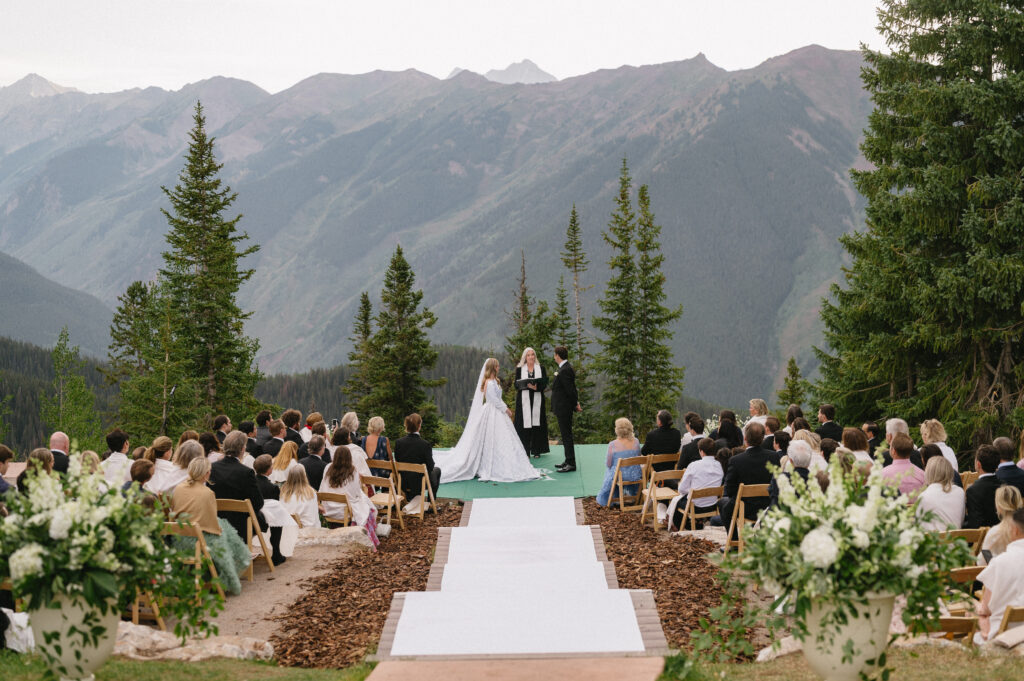 A bride and groom stand for their wedding ceremony in front of the mountains in Aspen, CO